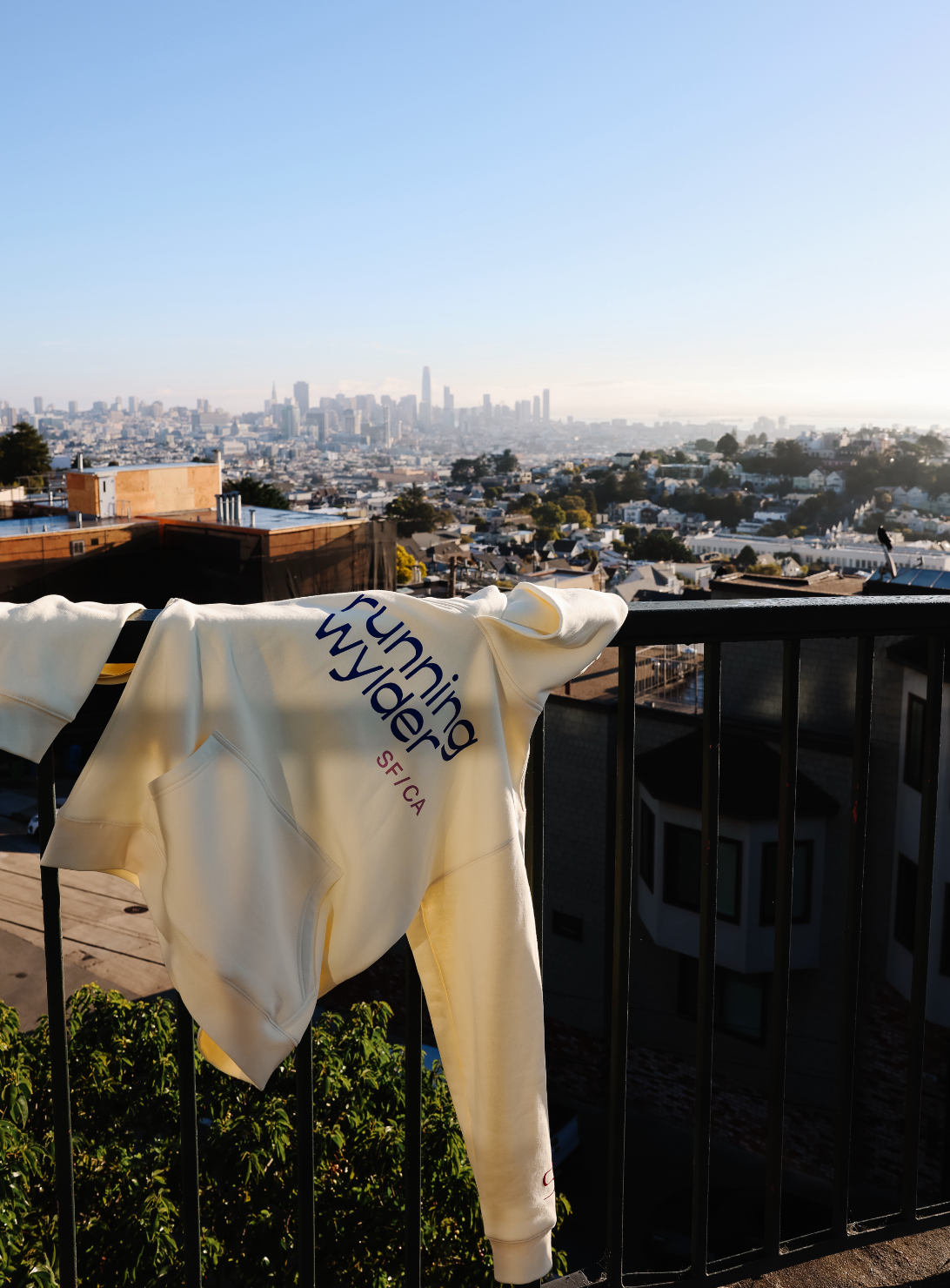 Hoodie with Running Wylder logo on balcony overlooking San Francisco